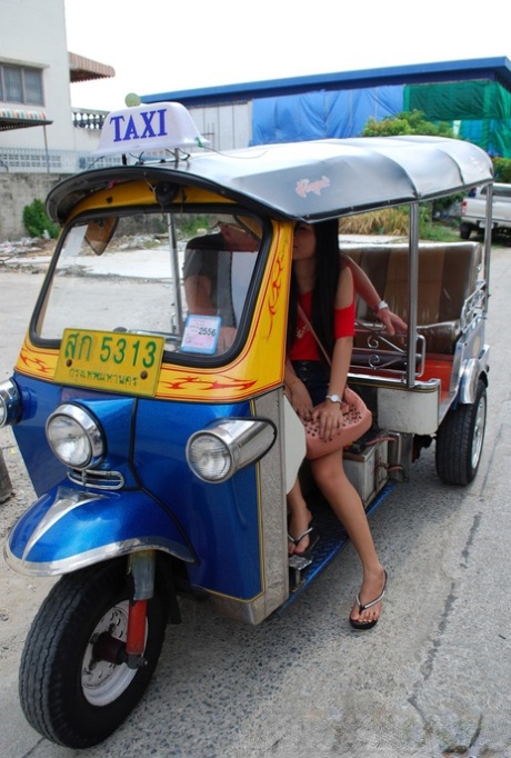 In a tuk tuk, Bew, an Asian, showcases her radiant feet while wearing booty shorts.