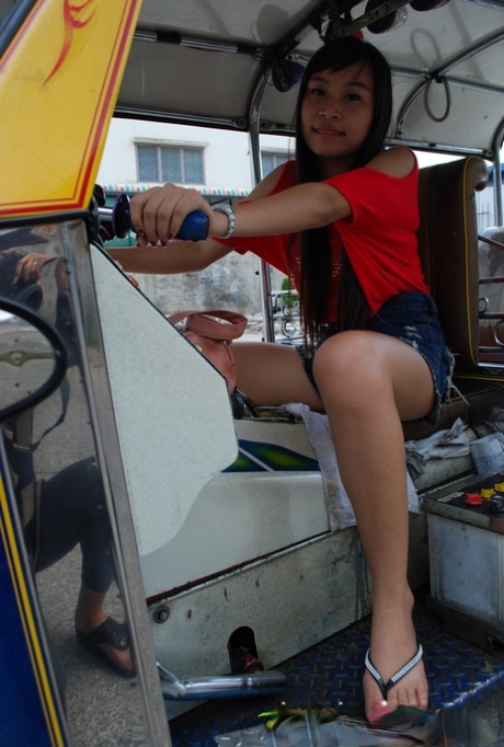 Bew, a pretty Asian, models her tuk tuk while flaunting her booty in the process.