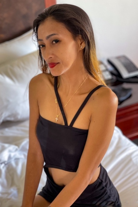 The petite Asian beauty, Mjane, flaunts her figure in a provocative black attire.