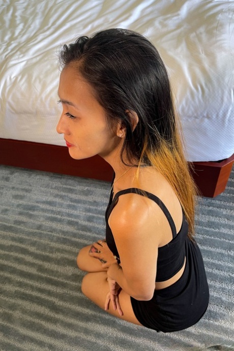 Asian beauty Mjane displays her petite figure in a provocative black attire.