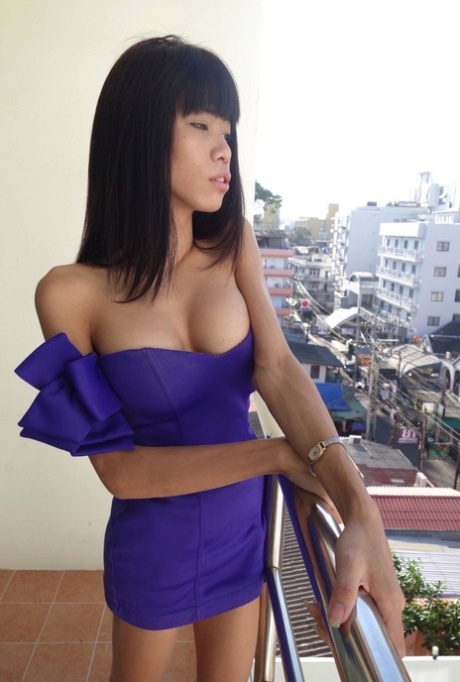 Jenny, the lovely lady with a cute moustache, flaunts her breasts while sitting on the balcony in her purple dress.