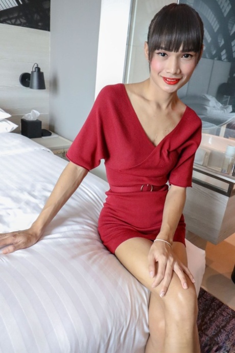 An Asian shemale named Brunette Mei removes her red dress and wears undies.