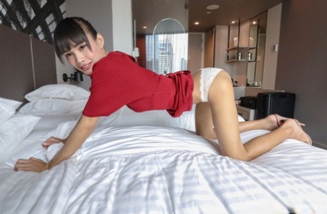 Brunette Asian shemale Mei removes her red dress and poses in undies