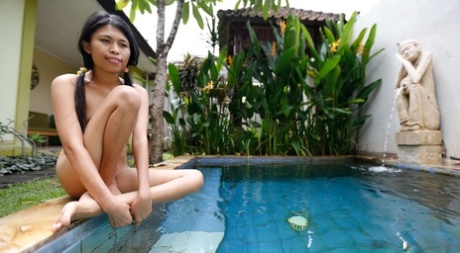 Cute Asian teen Adelia shows off her sexy body & gets in the pool while naked