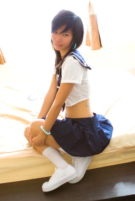 In her uniform, Puy a young Asian schoolgirl shows off some of the skinny legs she has on.