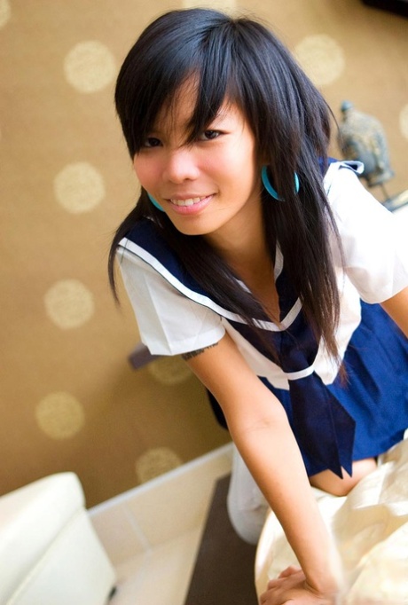 Asian schoolgirl Puy shows off her svelte figure by disarming in her uniform.