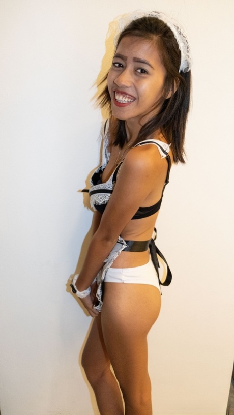 Danica, a tiny Asian maid in her uniform, exposes her breasts.