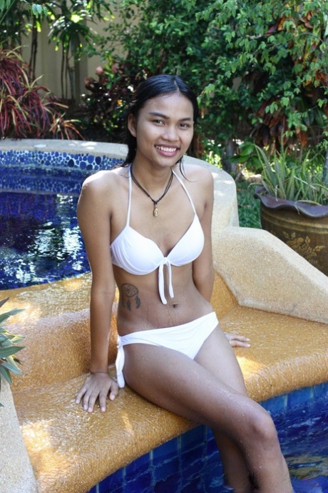 Beautifully cut Asian woman who takes a swim in the pool while stripping off beneath her jeans and wearing bikinis for photos.