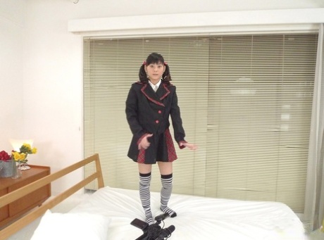 The Asian woman Anri Kawai bends over a bed and uses her panties to poke holes.