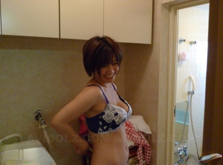 Meguru Kosaka, the Japanese homemaker with short hair, receives sexual stimulation from her partner while ruffling her hair.