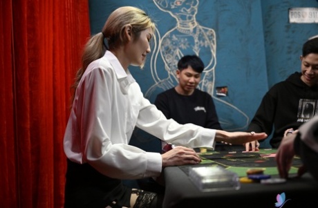 During the casino table, Li Zhiyan's attractive blonde partner gives him an amphibious blowjob.