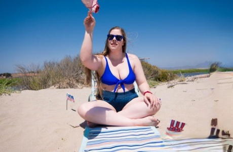 In the sun, Lana Del Lust, the chubby seductress, exposes her curves on a sandy beach.