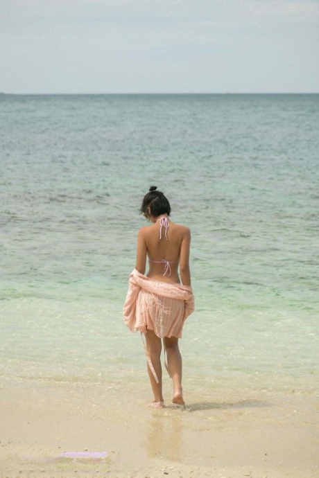 Stylish Asia female showcases her curvaceous curves and tiny fibula at the seaside.