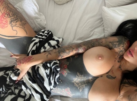 Sunny Free, the tattooed beauty from OnlyFans, displays her prominent breasts in her strips.