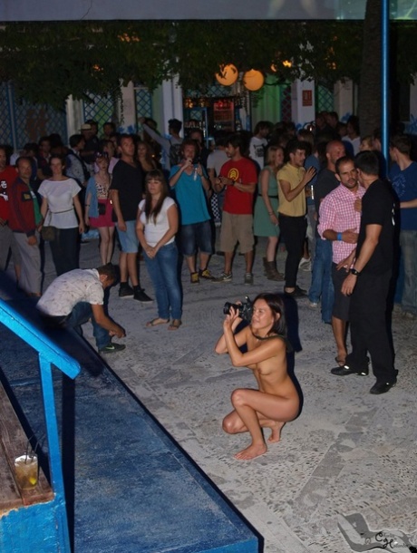 Non-decent young women posing in front of cameras without clothes to hide their nudity.