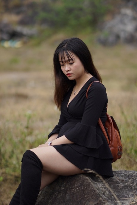 Gorgeous Asian Babe Posing In Her Black Dress And Boots In Nature