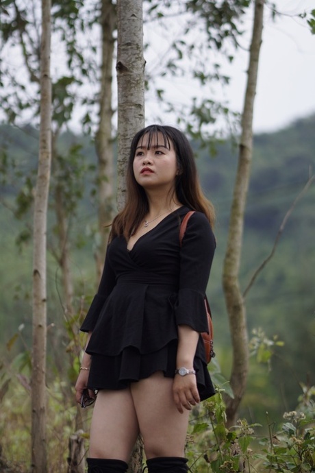 Gorgeous Asian Babe Posing In Her Black Dress And Boots In Nature