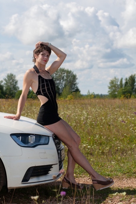 Short-haired Beauty Posing In Her Provocative Dress Next To Her Car Outside