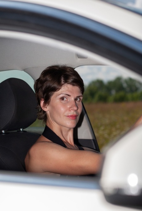 Short-haired Beauty Posing In Her Provocative Dress Next To Her Car Outside