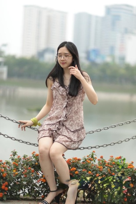 Exquisitely dressed as an outdoor model, the Asian girl exudes confidence while wearing a suggestive short dress.