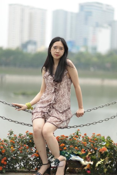 An attractive Asian woman exudes confidence while wearing a short dress.