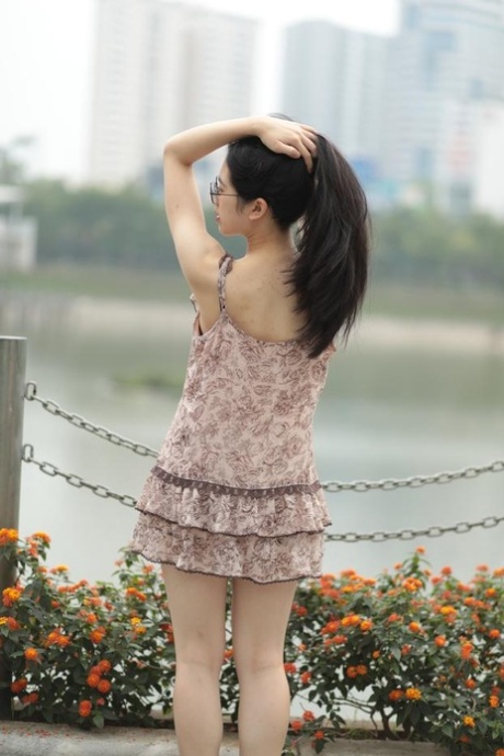 An attractive East Indian woman strums in an alluring short dress while enjoying the outdoors.