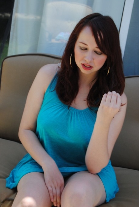 Chubby brunette posing on the couch while wearing her gorgeous blue dress.