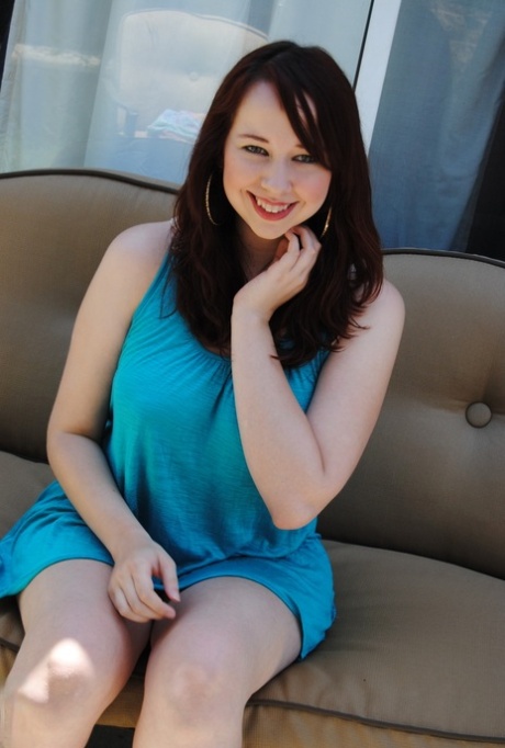 A choosy amateur in her blue dress sitting on the sofa.