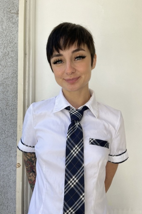 Stevie Moon, a brunette schoolgirl, displays her freshly shaved face as she kisses her puffy pussy.