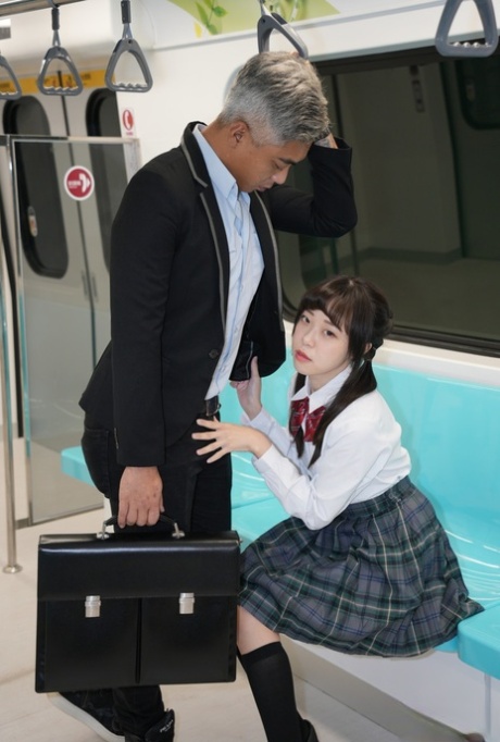 Yuli, an Asian schoolgirl, engages in sexual activity with a senior on the train while doggystyle.