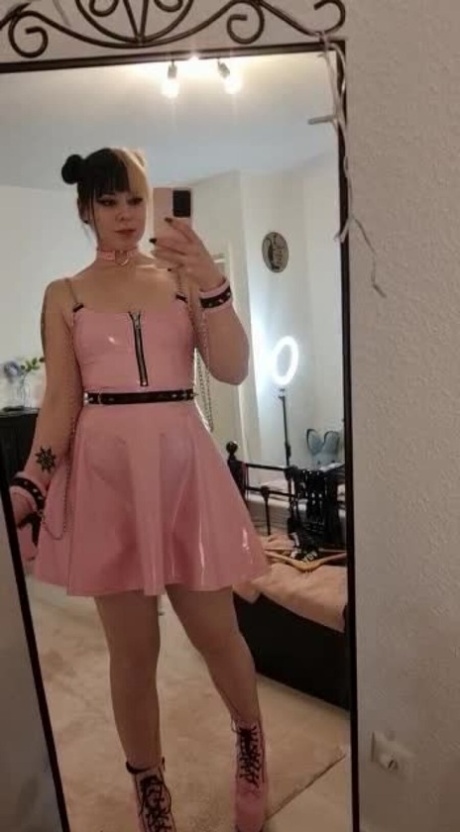 The naked Kira Jameson, a seductive amateur, models herself in her pink latex dress and high heels for a solo performance.