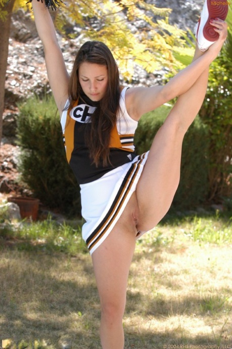 A brunette cheerleader with a dark hairstyle, Michelle exercises in public.