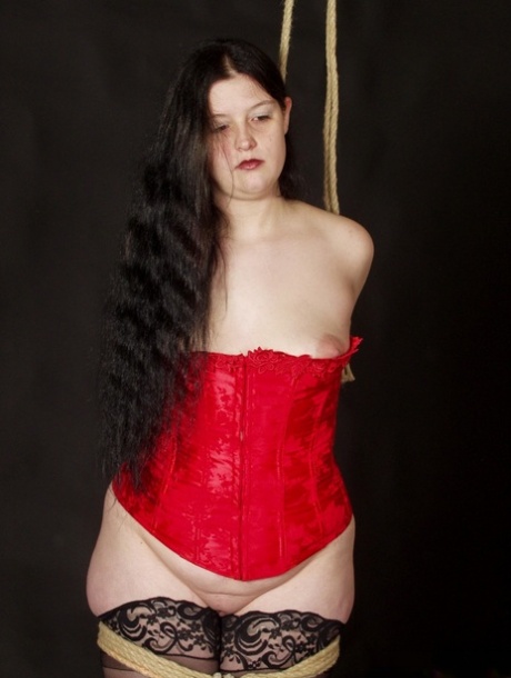To tie Slavegirl Emma up for rope bondage, a male handler secures the braided hair.