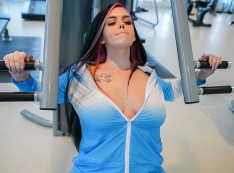 Ryan Smiles exhibits her ample chest muscles during a workout routine.