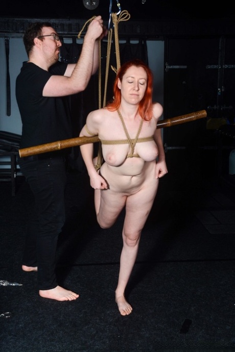 Full of her clothes: Chubby redhead Amber is tied up in rope bondage.