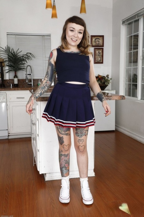 An amateur with tattoos, Felicia Fisher displays her hairy crotch and small legs.