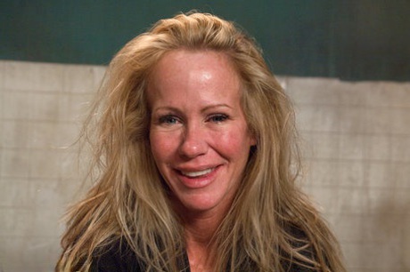 A 48-year-old blonde named Simone Sonay experiences a painful ordeal while being restrained by a table.