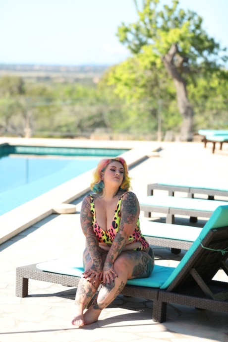 Sexy BBW takes off her swimsuit outside in a colorful outfit and displays her tattooed body.