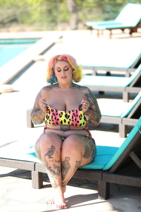 BBW, the seductive lady, exposes her tattooed body while disguising herself in her colorful swimsuit.