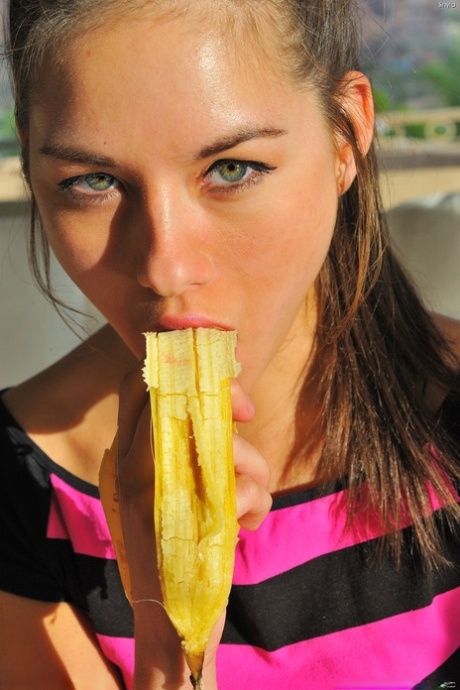 A banana is consumed by Shyla, a delightful young woman, during her yoga practice after class.