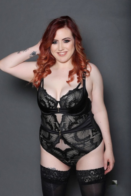 Chubby redhead Freyja gets her boobs out while posing in her lace lingerie