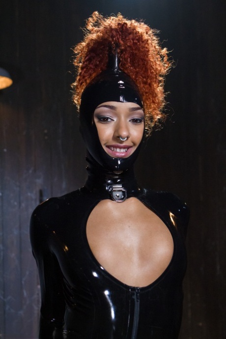 The ebony sexy redheaded Daisy Ducati, who is covered in latex and has red hair, is bound and toyed with.