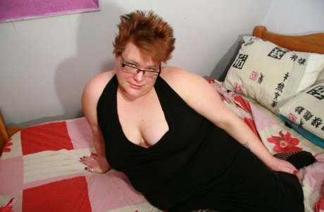 The short-haired BBW Lucky was seen stripping to her stockings and playing with her oversized pussy.