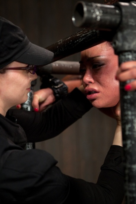 Mia Lelani, a member of the Asian League, receives a punishment of wearing metal bonds and using a dildo.