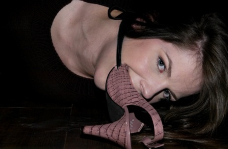 While bound barefoot, Bobbi Starr indulges in an oral act by sucking on her high heel shoe.