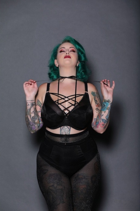 The chubby gal with green hair is known as Galda Lou, and she displays an inked body and big tits.