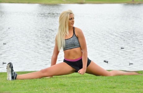 Kaylie, a petite blonde woman, removes her fitness shorts and performs a handstand without clothing.