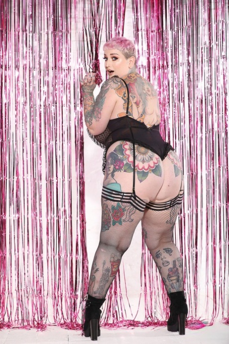 With her tattooed body on display, Galda Lou looks sexy in a combination of tight fitting stockings and boots.