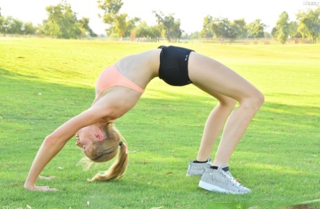 A petite and butty amateur named Mazzy exhibits her blonde features while posing for the outdoor stage.