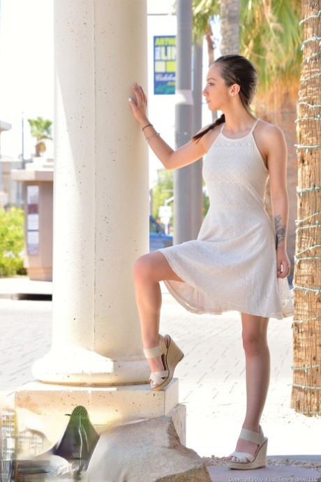 With a cute white dress on her feet, Lily showcases her petite frame in high heels.